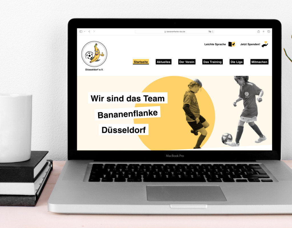 Ein Laptop steht auf einem Schreibtisch. Auf seinem Bildschirm ist die Startseite der Website zu sehen.